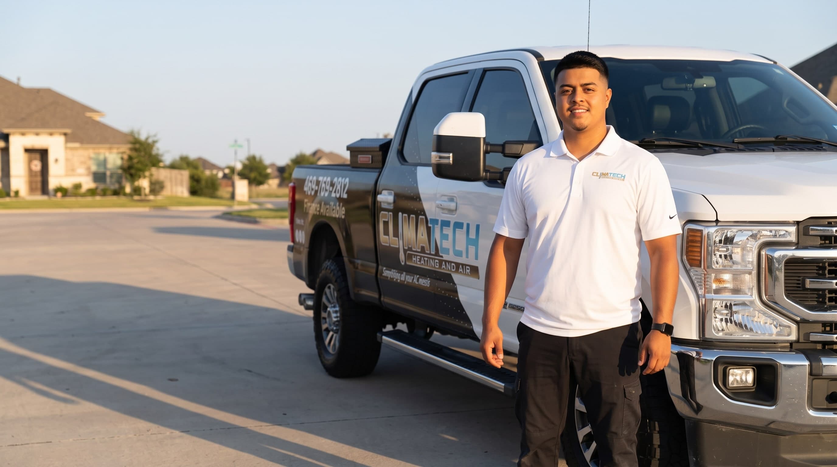 Alex, the owner of Climatech Heating and Air, beside the service truck at golden hour